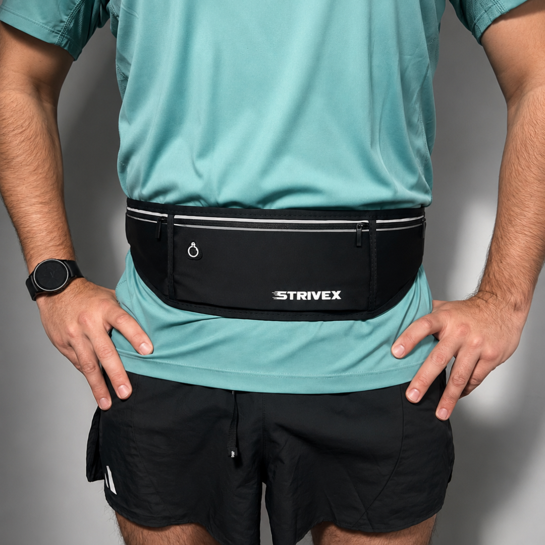 A man wearing a black Strivex running waist pack with white piping and a white logo, worn over a teal athletic shirt and black shorts.