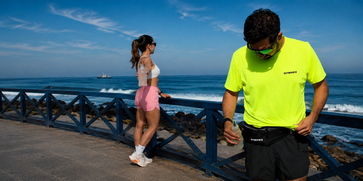 Two athletes training by the ocean with the strivex equipment waist bag and soft flask bottle