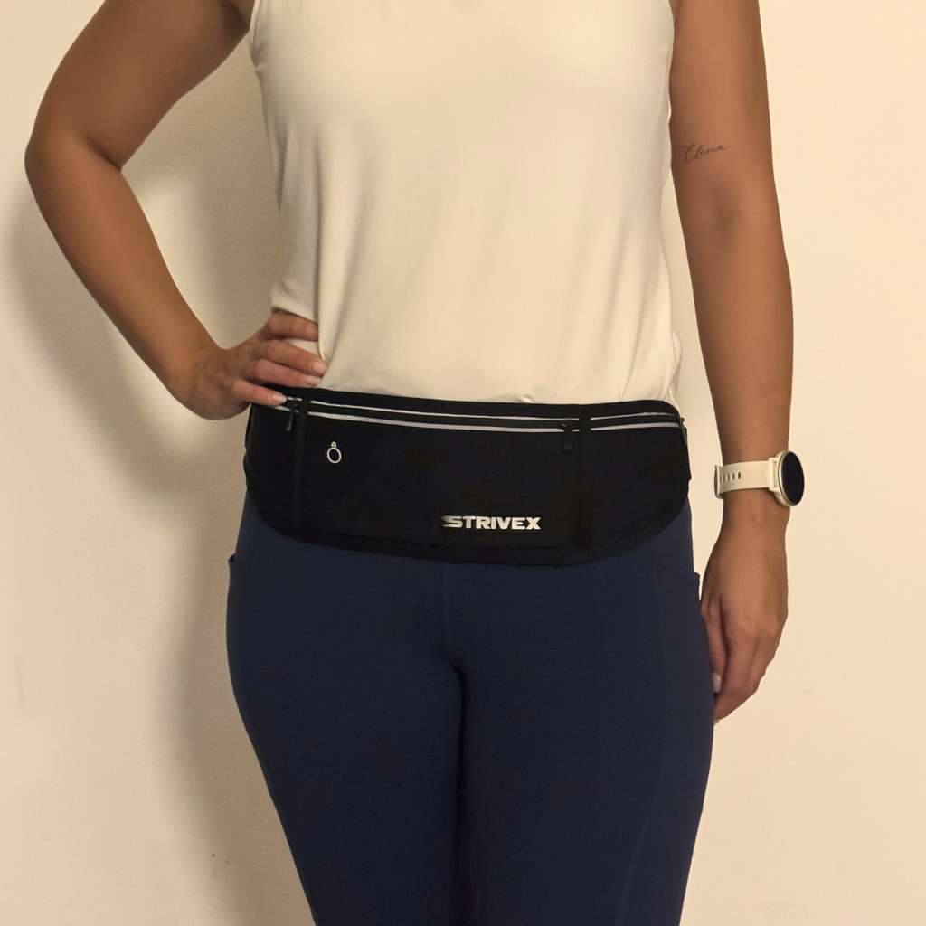 A person wearing a black Strivex waist bag with reflective trim