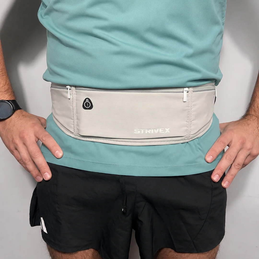 A grey Strivex running waist pack worn by a model in a teal t-shirt and black short