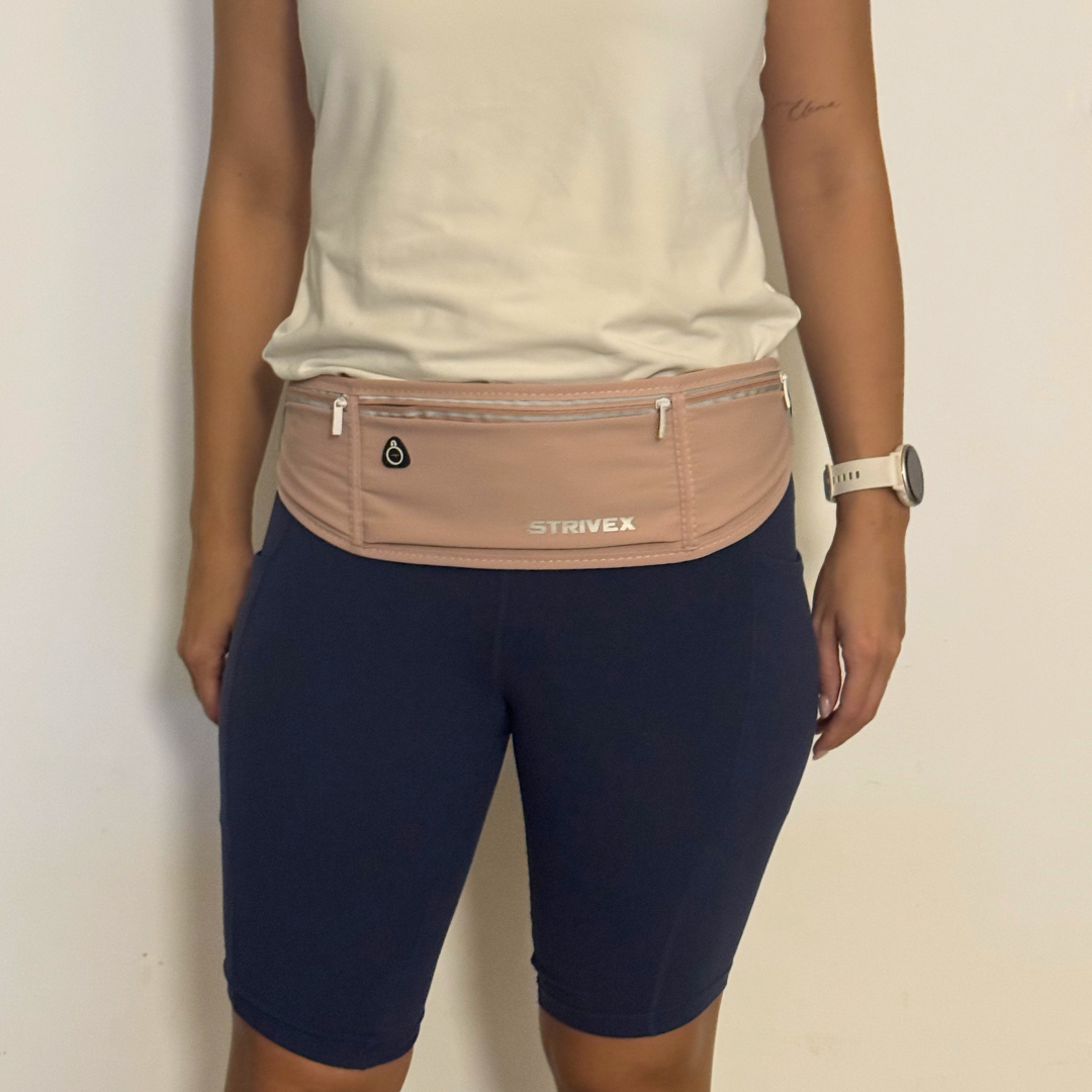 A person wearing a pink Strivex athletic waist bag over navy